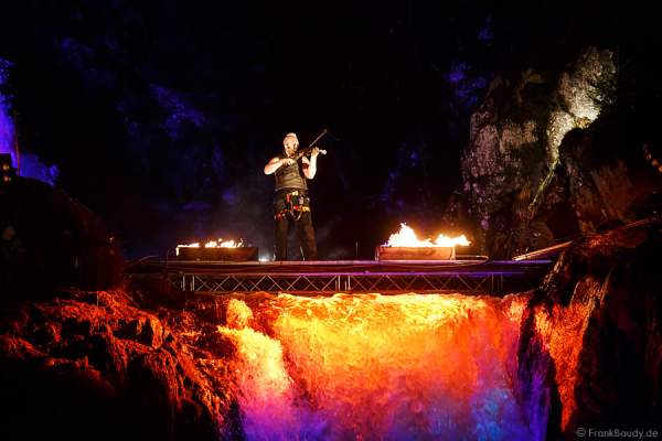 Hannes Schwarz mit Geige bei seiner Feuershow am Wasserfall des Triberger Weihnachtszauber
