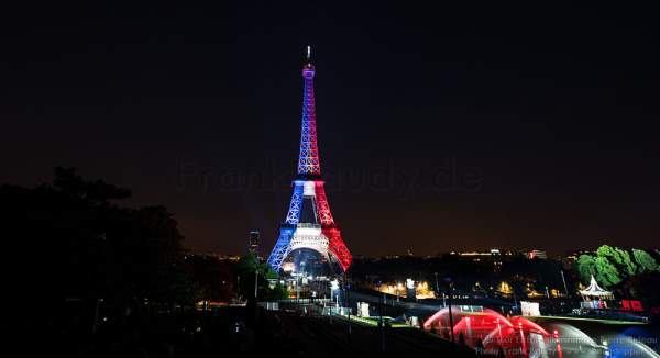 Beleuchteter Eiffelturm in Tricolor bei Nacht vor dem Feuerwerk beim Nationalfeiertag am 14. Juli 2016 in Paris