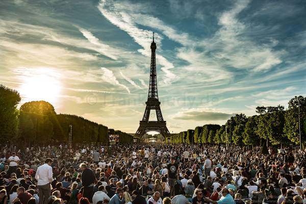 Besucher auf dem Champ de Mars warten am Abend auf das Konzert und das Feuerwerk auf dem Eiffelturm beim Nationalfeiertag am 14. Juli 2017 in Paris