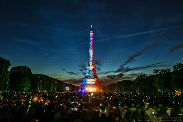 Beleuchteter Eiffelturm in Tricolor bei Nacht vor dem Feuerwerk beim Nationalfeiertag am 14. Juli 2017 in Paris