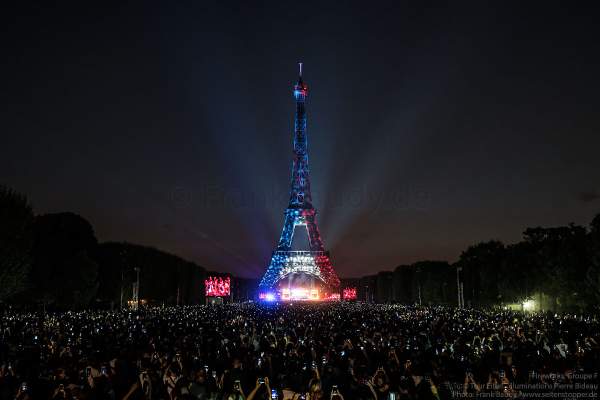 Beleuchteter Eiffelturm in Tricolor bei Nacht vor dem Feuerwerk beim Nationalfeiertag am 14. Juli 2018 in Paris