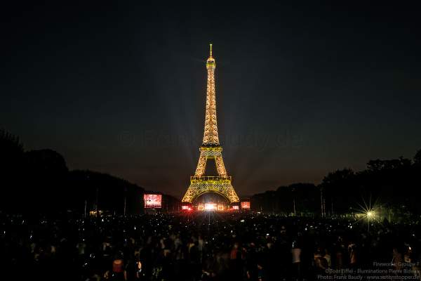 Besucher auf dem Champ de Mars warten am Abend auf das Konzert und das Feuerwerk auf dem Eiffelturm beim Nationalfeiertag am 14. Juli 2018 in Paris