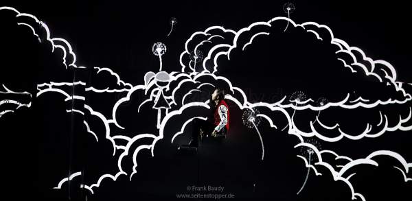 DJ BoBo spielt mit einem Mädchen einer Zeichentrickanimation auf der Bühne bei der Show KaleidoLuna