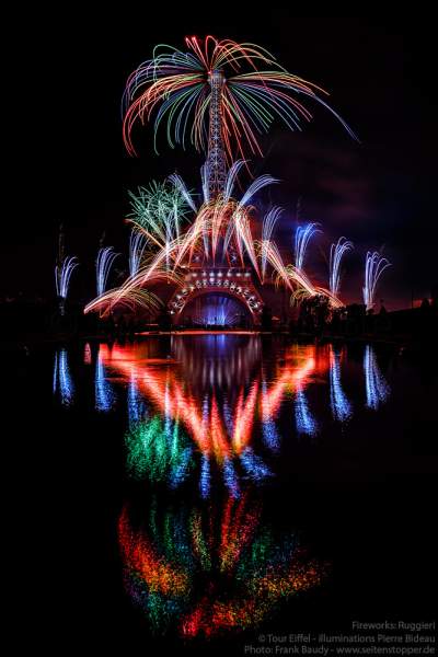 Der Eiffelturm mit spektakulärem Feuerwerk spiegelt sich im Wasser beim Nationalfeiertag am 14. Juli 2019 in Paris