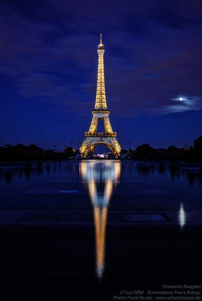 Illuminierter Eiffelturm bei Nacht spiegelt sich im Wasser vor dem großen Feuerwerk zum Nationalfeiertag am 14. Juli 2019 in Paris