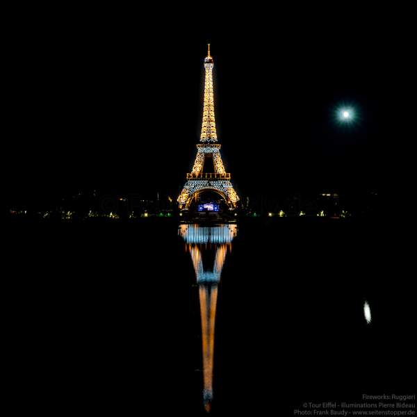 Illuminierter Eiffelturm bei Nacht spiegelt sich im Wasser vor dem großen Feuerwerk zum Nationalfeiertag am 14. Juli 2019 in Paris