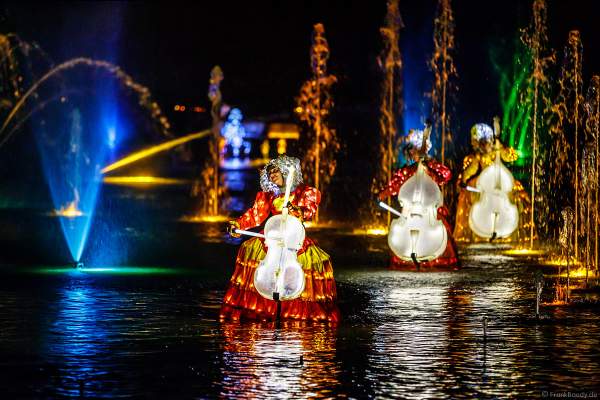 Romantische Wassershow Les Orgues de Feu (Die Feuerorgel) mit Darstellen in wunderschönen Leuchtkostümen im Freizeitpark Puy du Fou in Frankreich