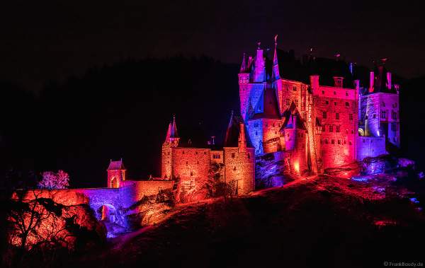Farbenprächtig beleuchtete Burg Eltz bei Nacht bei dem Event Illumination Eltzer Burgpanorama
