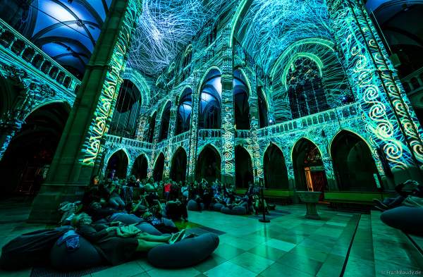Auf großen Sitzkissen kann man bequem die immersive Lichtshow 'GENESIS' in der Johanneskirche in Stuttgart erleben