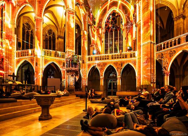 Auf großen Sitzkissen kann man bequem die immersive Lichtshow 'GENESIS' in der Johanneskirche in Stuttgart erleben