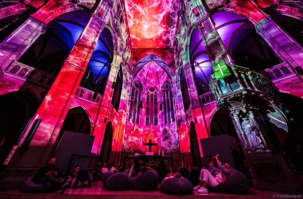 Auf großen Sitzkissen kann man bequem die immersive Lichtshow 'GENESIS' in der Johanneskirche in Stuttgart erleben
