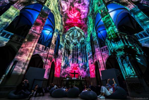 Auf großen Sitzkissen kann man bequem die immersive Lichtshow 'GENESIS' in der Johanneskirche in Stuttgart erleben