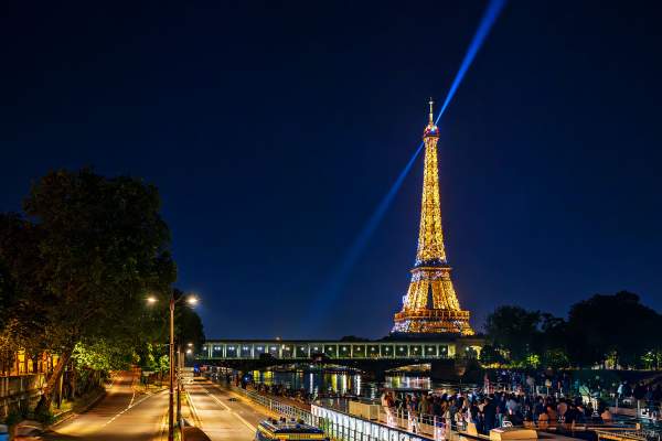 Eiffelturm in Paris bei Nacht beim Nationalfeiertag am 14. Juli 2024 mit den Olympischen Ringen