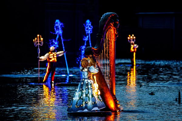 Tänzer in Leuchtkostümen bei der Abendshow Les Noces de Feu im Freizeitpark Puy du Fou