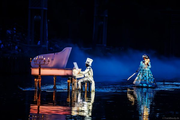 Tänzer in Leuchtkostümen bei der Abendshow Les Noces de Feu im Freizeitpark Puy du Fou
