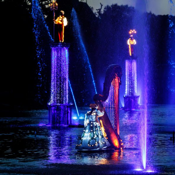 Tänzer in Leuchtkostümen bei der Abendshow Les Noces de Feu im Freizeitpark Puy du Fou