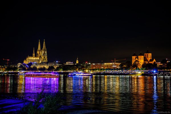 Die beleuchteten Ausflugsschiffe werden von einem Meer aus Handylichter zur den Kölner Lichter begrüßt.