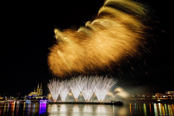 Glitzernde Pyro-Effekte erleuchten den Nachthimmel bei den Kölner Lichtern über dem Rhein und Dom