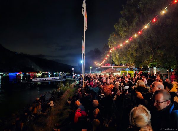 Am Ufer warten zahlreiche Besucher gespannt auf das Musikfeuerwerk bei Rhein Flammen in Oberwesel 2025