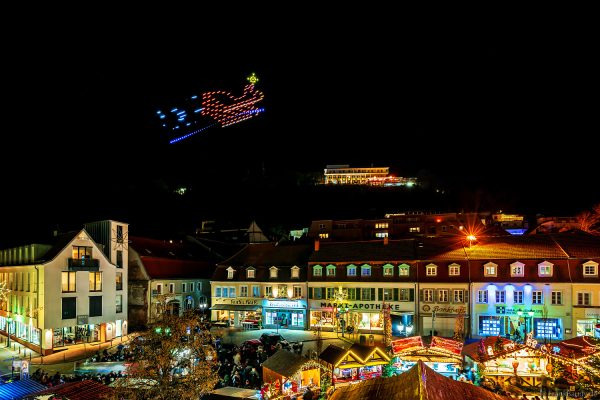 Stimmungsvolle Abendaufnahme mit Drohnenshow und weihnachtlich beleuchteten Buden in Homburg