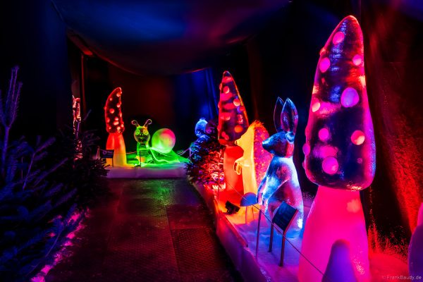 Bunt beleuchtete Eisskulpturen, die in Form von Pilzen, Tieren und Kindern