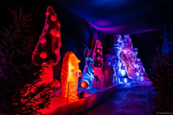 Bunt beleuchtete Eisskulpturen, die in Form von Pilzen, Schnecken und Kindern