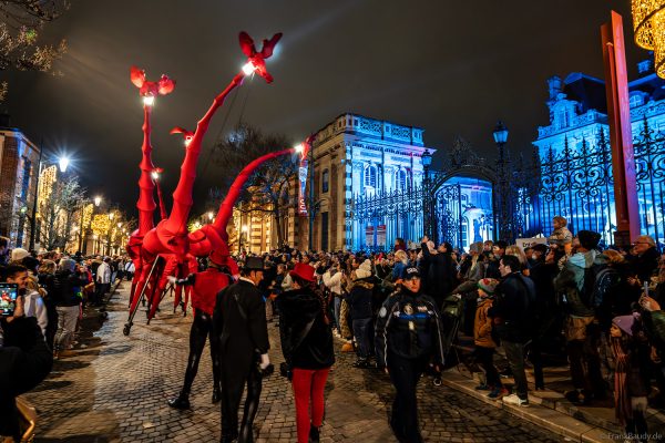 Riesige Giraffenfiguren ziehen durch die Avenue de Champagne bei Nacht
