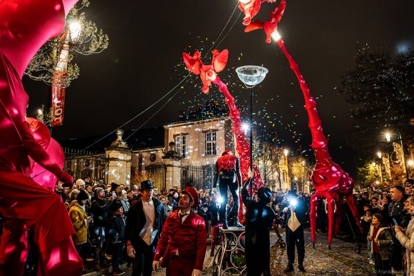 Riesige rote Giraffen von Compagnie Off ziehen durch die Avenue de Champagne bei Habits de Lumière