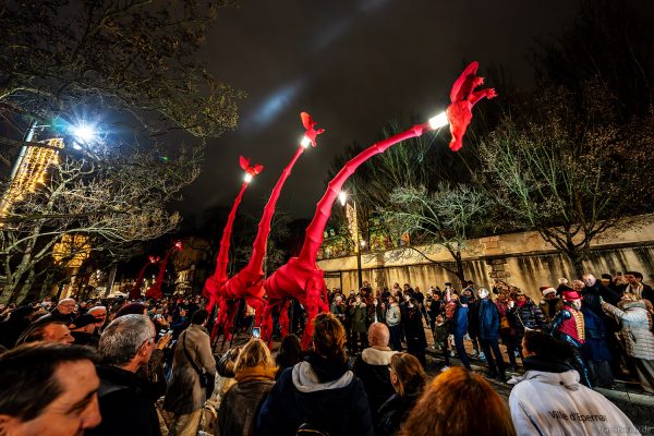 Riesige rote Giraffen von Compagnie Off ziehen durch die Avenue de Champagne bei Habits de Lumière