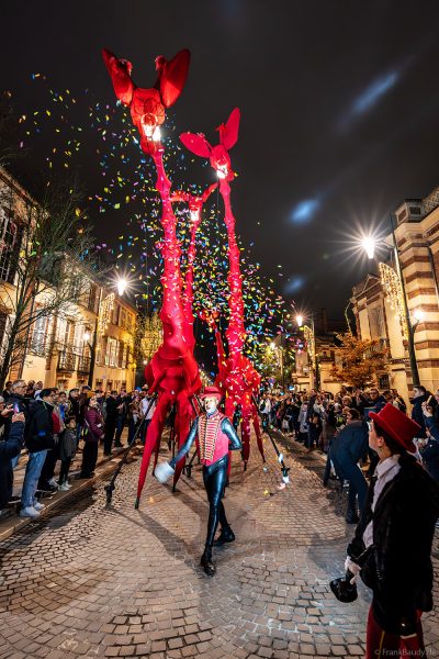 Riesige rote Giraffen von Compagnie Off ziehen durch die Avenue de Champagne bei Habits de Lumière