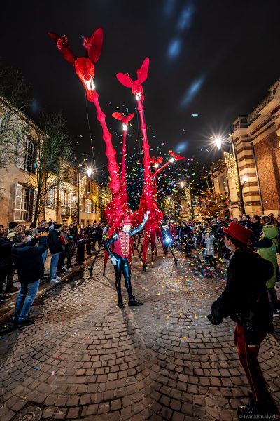 Riesige rote Giraffen von Compagnie Off ziehen durch die Avenue de Champagne bei Habits de Lumière