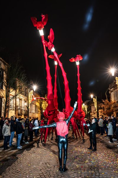 Riesige rote Giraffen von Compagnie Off ziehen durch die Avenue de Champagne bei Habits de Lumière
