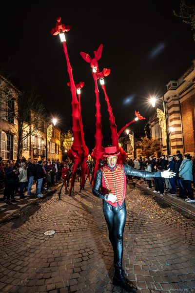 Riesige rote Giraffen von Compagnie Off ziehen durch die Avenue de Champagne bei Habits de Lumière