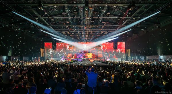 Akrobaten als spiegelnde Lichtgestalten fliegen durch die Halle beim DJ BoBo Konzert – The Great Adventure