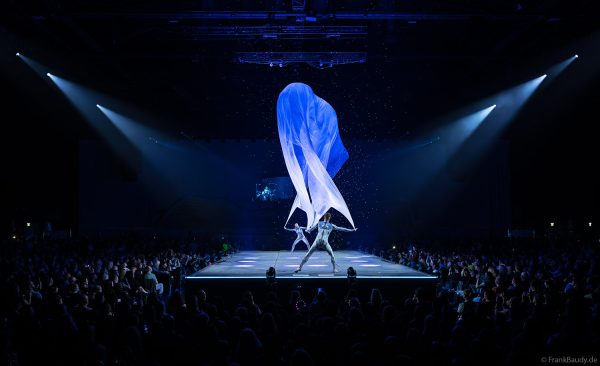 Turner performen mit einem Tuch im Luftstrom eindrucksvoll im Licht auf der Bühne bei DJ BoBo – The Great Adventure