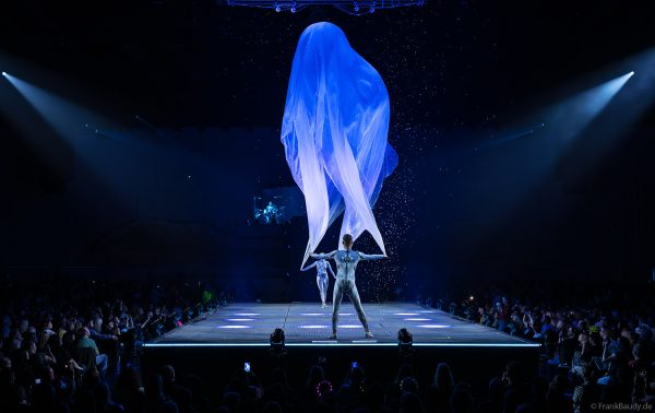 Turner performen mit einem Tuch im Luftstrom eindrucksvoll im Licht auf der Bühne bei DJ BoBo – The Great Adventure