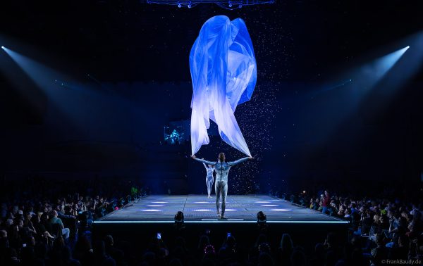 Turner performen mit einem Tuch im Luftstrom eindrucksvoll im Licht auf der Bühne bei DJ BoBo – The Great Adventure