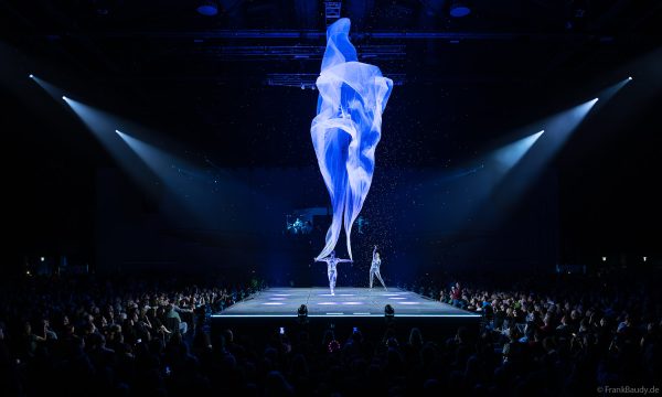 Turner performen mit einem Tuch im Luftstrom eindrucksvoll im Licht auf der Bühne bei DJ BoBo – The Great Adventure