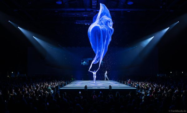 Turner performen mit einem Tuch im Luftstrom eindrucksvoll im Licht auf der Bühne bei DJ BoBo – The Great Adventure